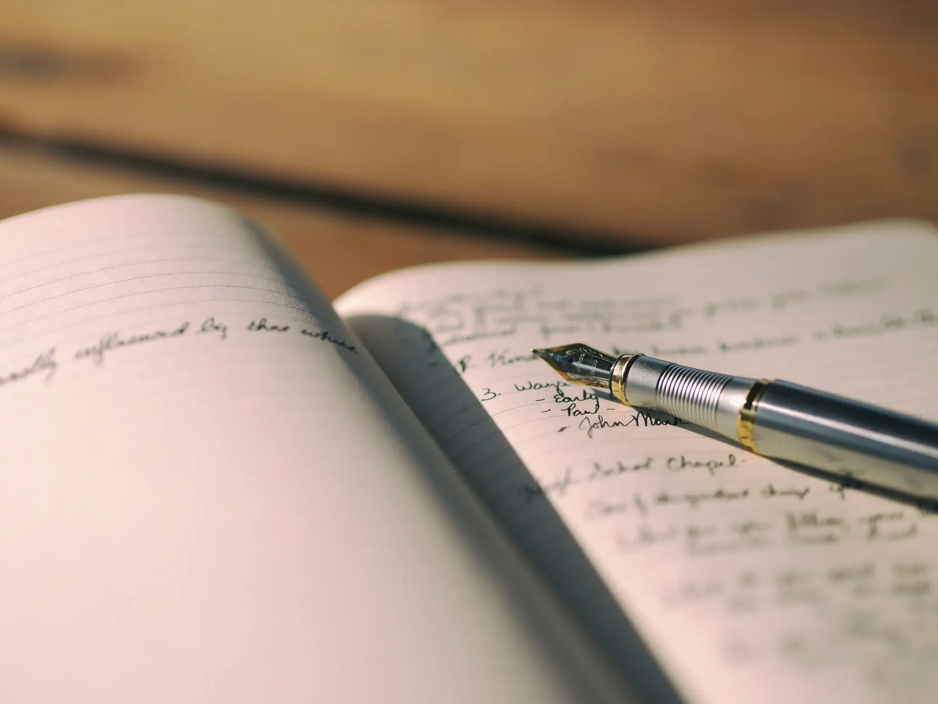 Handschriftliche Begriffsliste in einem aufgeschlagenen Notizbuch neben einem Füller