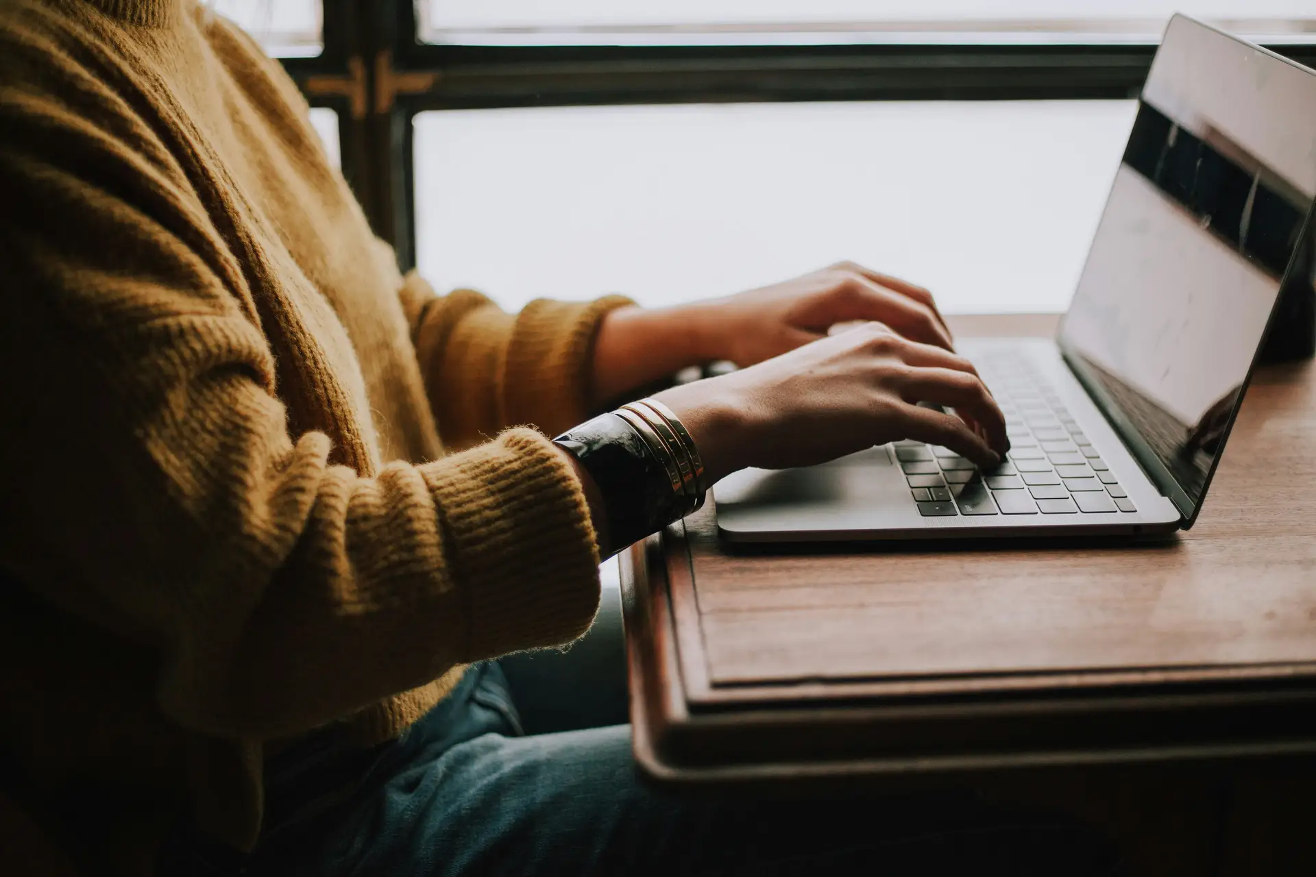 Person tippt am Laptop einen Prompt in ein KI-Chatfenster