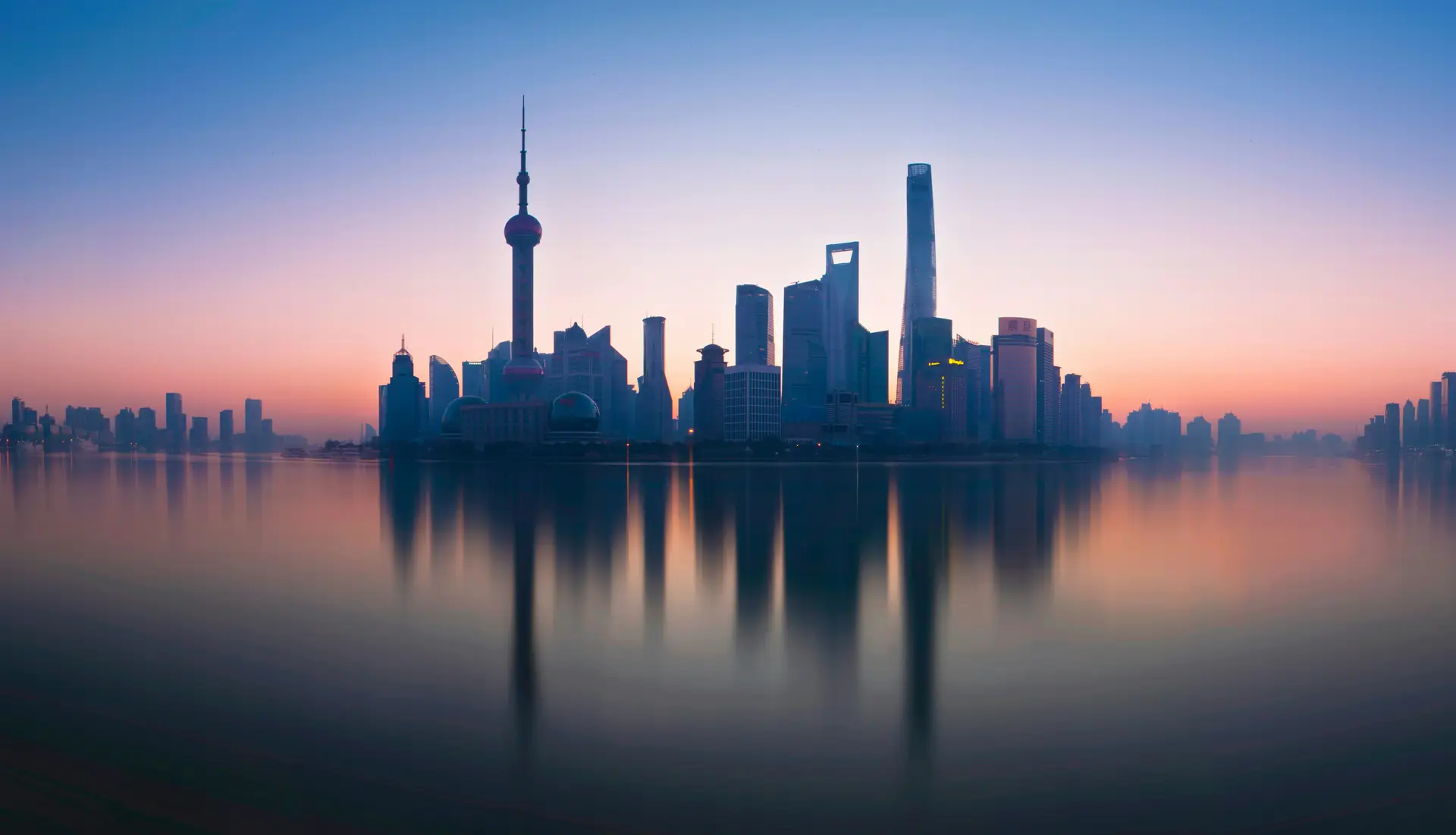 Wachsende Skyline einer Metropole in einem Schwellenland mit Hochhäusern und Baukränen im Abendlicht