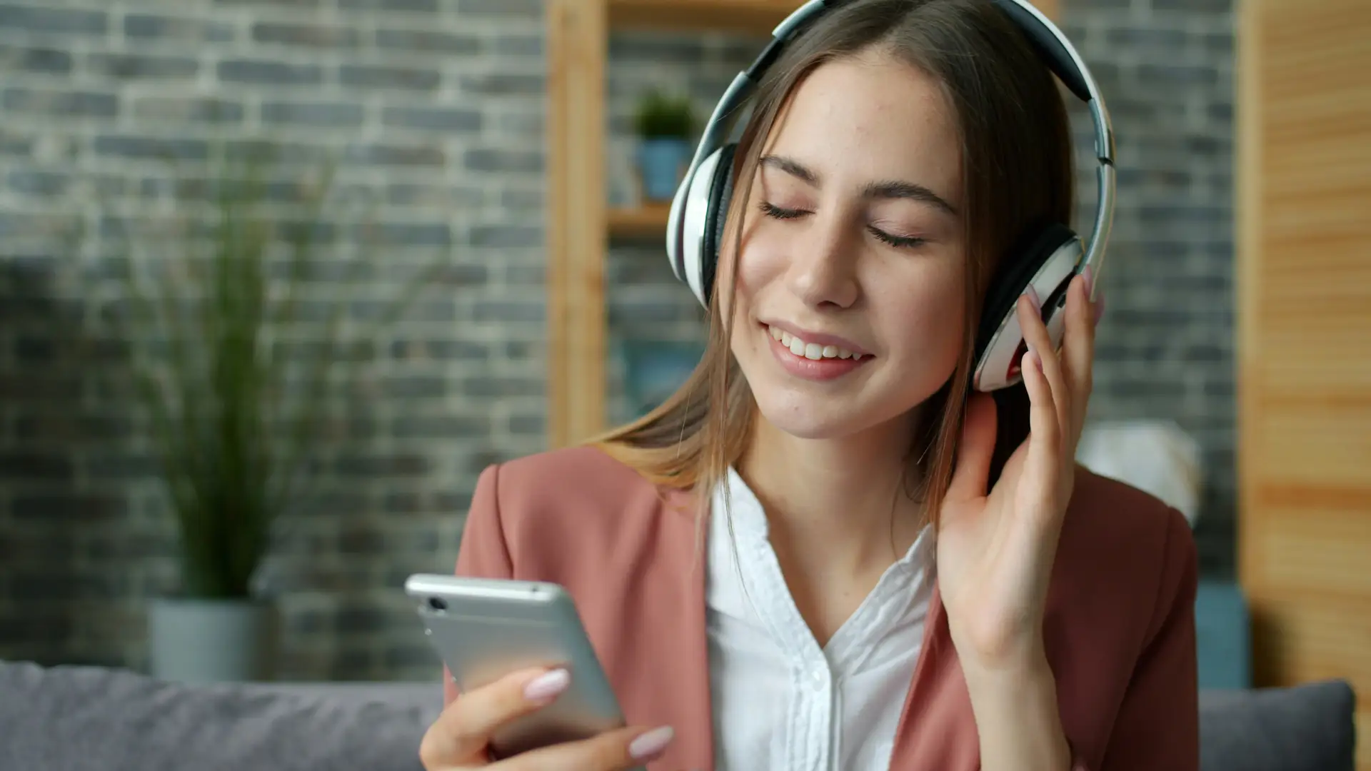 Eine Person hört eine WhatsApp-Sprachnachricht am Smartphone ab, um sie zu übersetzen.