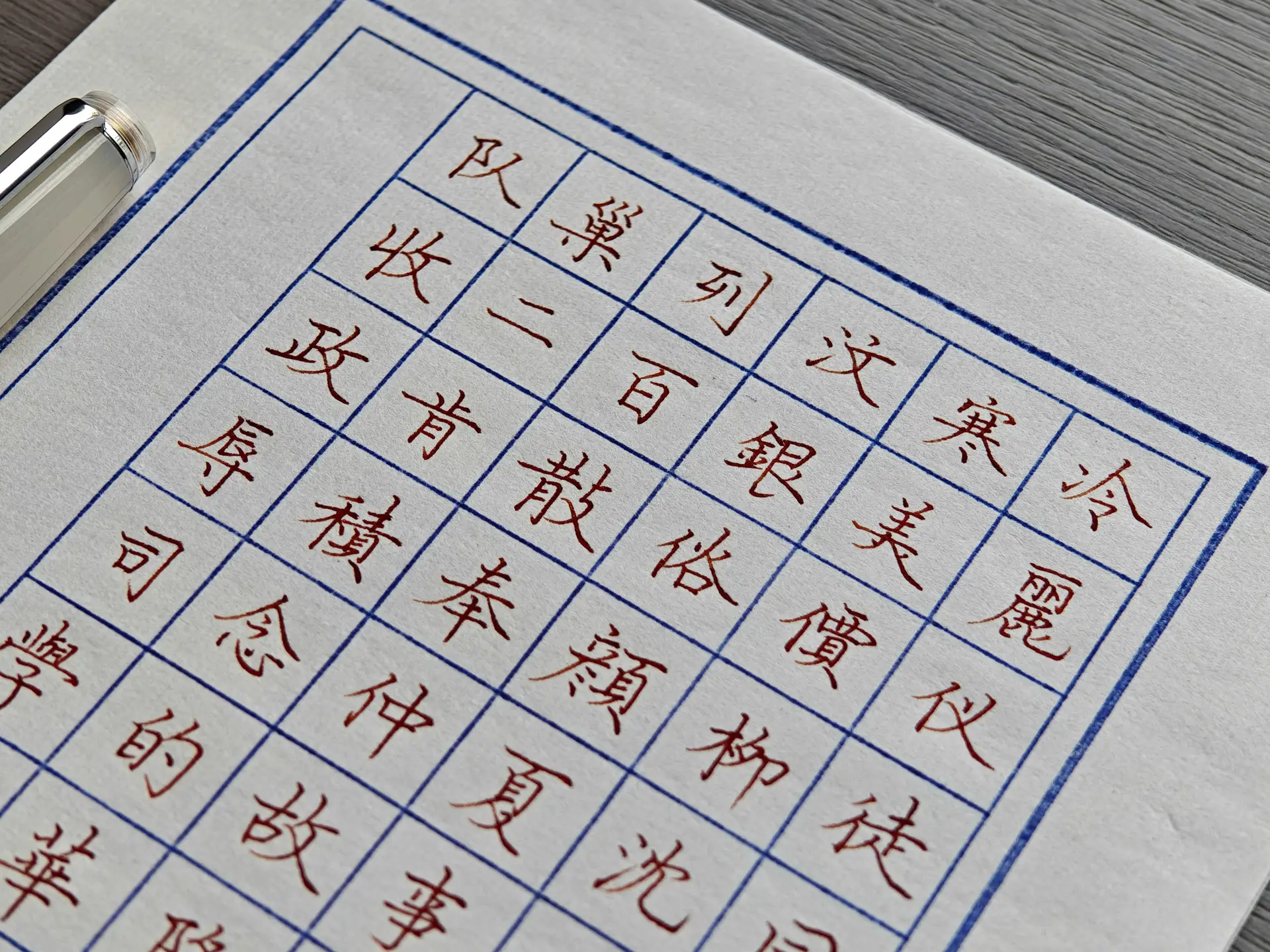Nahaufnahme mehrerer Schriftsysteme nebeneinander auf Rasterpapier