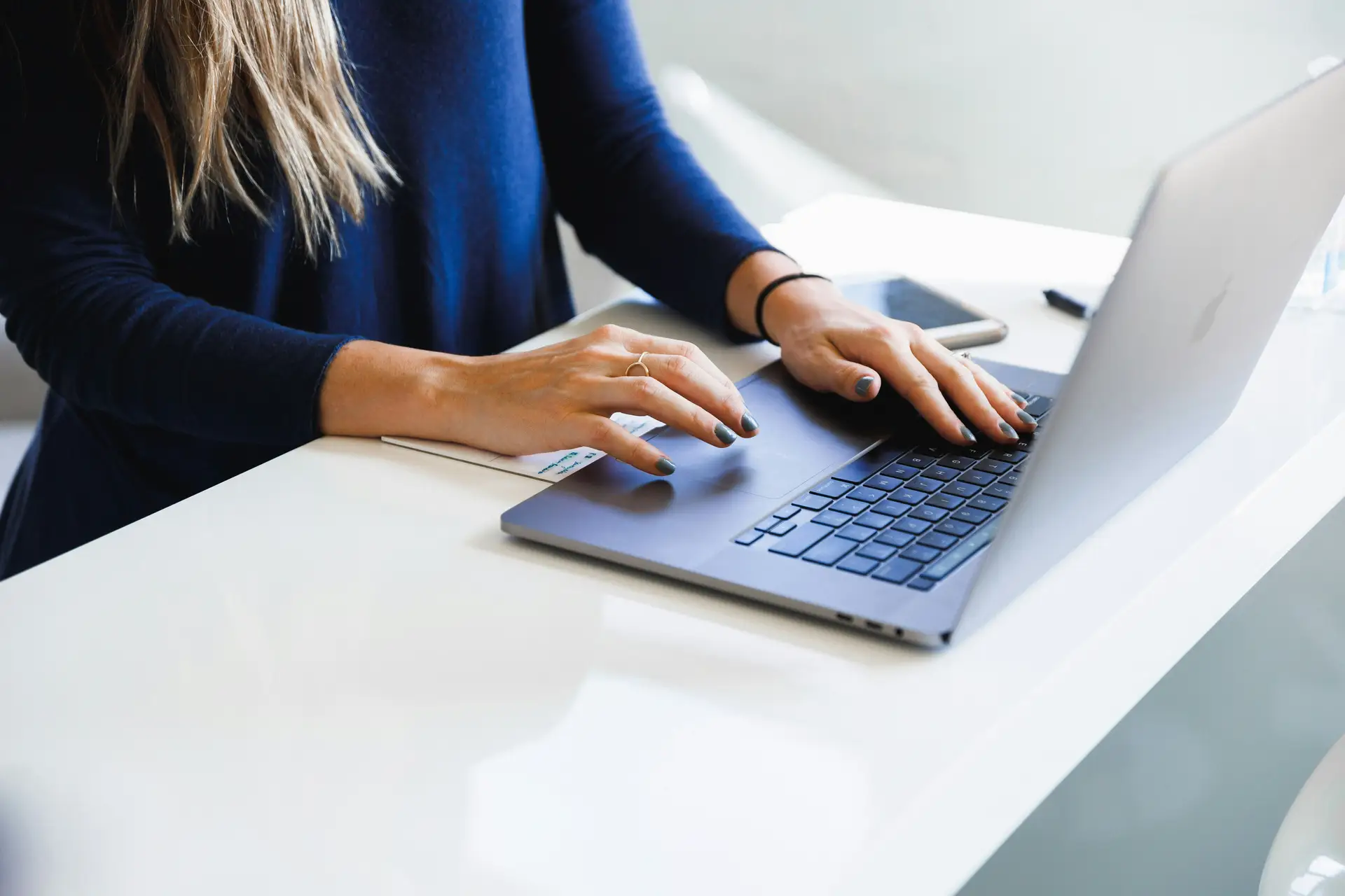 Hände tippen auf einer Laptop-Tastatur mit Übersetzungssoftware auf dem Bildschirm